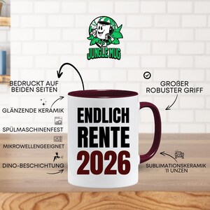May include: White ceramic mug with a burgundy interior and handle. The mug features the text "ENDLICH RENTE 2026" in black and burgundy. The mug has a cartoon logo of a mug with headphones. The mug is 11 ounces.