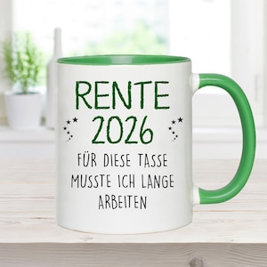 Pu&ograve; includere: Tazza in ceramica bianca con interno e manico verdi. La tazza presenta il testo "RENTE 2026" in verde, insieme alla frase "F&Uuml;R DIESE TASSE MUSSTE ICH LANGE ARBEITEN" in nero. Piccole stelle decorative.