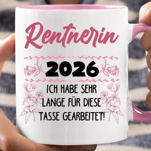 May include: White ceramic mug with a pink interior and handle. The mug features the text "Rentnerin 2026" in pink script, along with the phrase "ICH HABE SEHR LANGE F&Uuml;R DIESE TASSE GEARBEITET!" in black, and floral accents.