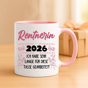 May include: White ceramic mug with a pink interior and handle. The mug features the word "Rentnerin" in pink script, the year "2026", and the German text "ICH HABE SEHR LANGE F&Uuml;R DIESE TASSE GEARBEITET!" in black. Floral accents decorate the design.