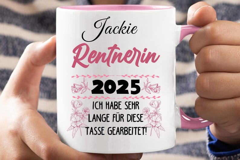 Puede incluir: Taza de cer&aacute;mica blanca con interior y asa rosas. La taza presenta el nombre "Jackie" en escritura negra, la palabra "Rentnerin" en escritura rosa, el a&ntilde;o "2025" y una frase alemana en texto negro.