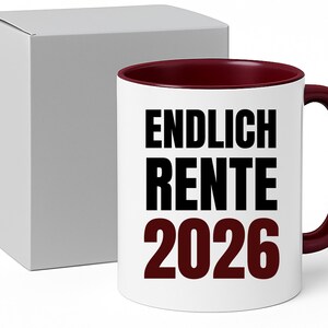 May include: White ceramic mug with a burgundy interior and handle. The mug features the text "ENDLICH RENTE 2026" in black and burgundy. A white box is next to the mug.