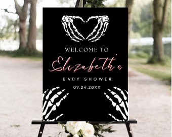 May include: Black and white welcome sign with a skeleton hand heart design. The sign reads "Welcome to Elizabeth's Baby Shower 07.24.20XX".