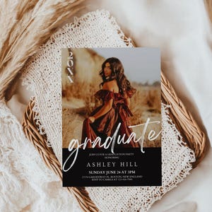 Op de afbeelding: Een uitnodiging voor een afstudeerfeest met een zwart-witte achtergrond. De uitnodiging bevat een foto van een vrouw in een rode jurk en de tekst "graduate" in wit handschrift. De tekst bevat ook de naam "Ashley Hill", de datum "zondag 24 juni om 15:00 uur" en het adres "17178 Gardenway Pl. Boston, New England".