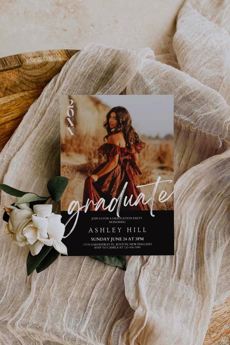 Op de afbeelding: Een zwart-witte uitnodiging voor een afstudeerfeest met een foto van een vrouw in een rode jurk. De tekst op de uitnodiging luidt "20XX graduate" en bevat de naam "Ashley Hill", de datum "Sunday June 24 at 3PM", het adres "17178 Gardenway Pl. Boston, New England" en de RSVP-informatie "RSVP to Camila at 123-456-7890".