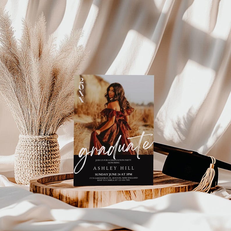 Op de afbeelding: Een zwart-witte uitnodiging voor een afstudeerfeest met een foto van een vrouw in een rode jurk. De tekst op de uitnodiging luidt "graduate" in wit handschrift en "Ashley Hill" in witte blokletters. De datum en tijd van het feest staan hieronder vermeld.