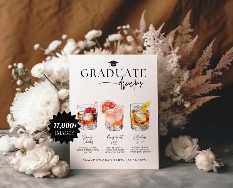 May include: A white sign with the words "GRADUATE Drinks" and illustrations of three cocktails. The sign also includes the text "17,000+ IMAGES" and "AMANDA'S GRAD PARTY | 14.06.2025". The background features white flowers and dried plants.