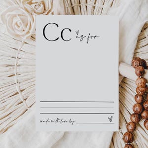 May include: A white card with the letter "C" and the text "C is for" written in black. There are two lines for writing and the text "made with love by:" at the bottom of the card.