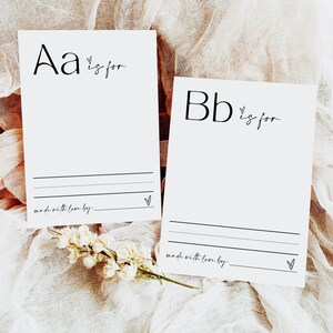 May include: Two white cards with black lettering. The first card says "Aa is for" and the second card says "Bb is for". Both cards have a small heart symbol and a line for writing.