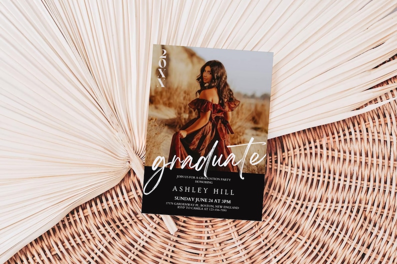 Op de afbeelding: Een zwart-witte uitnodiging voor een afstudeerfeest met een foto van een vrouw in een bruine jurk. De tekst op de uitnodiging luidt "graduate", "Join us for a graduation party", "Ashley Hill", "Sunday June 24 at 3PM", "1212 Cambridge St, Boston, MA 02139", "RSVP to Camila at 123-456-7890".