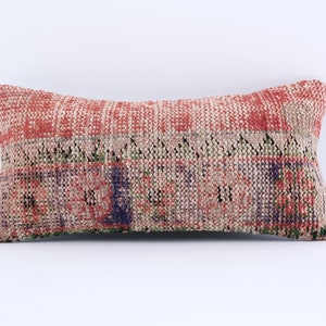 May include: A red, green and blue patterned throw pillow with a woven texture.