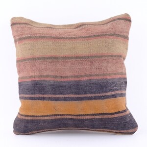 May include: A striped throw pillow with a woven texture in shades of brown, pink, orange, and blue.