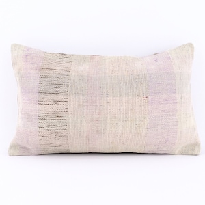 May include: A rectangular throw pillow with a woven pattern in shades of white, light purple, and brown. The pillow is made of a soft, textured fabric.