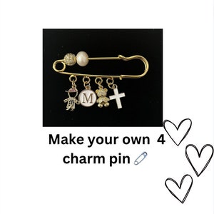 May include: Gold safety pin with four charms: a boy, a letter M, a teddy bear, and a cross.  Make your own 4 charm pin.