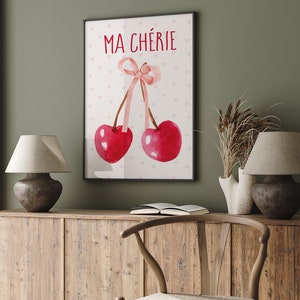 May include: A watercolor print with two red cherries and a pink ribbon. The text "MA CH&Eacute;RIE" is written in red at the top of the print.