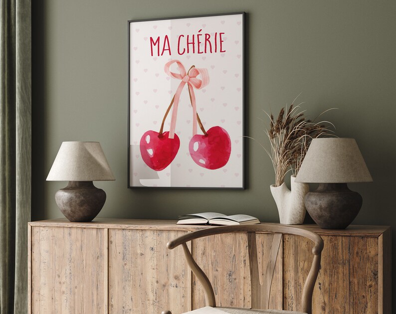 May include: A watercolor print with two red cherries and a pink ribbon. The text "MA CH&Eacute;RIE" is written in red at the top of the print.