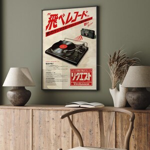 May include: A vintage poster advertising a Technics record player. The poster features a black and silver record player with a red record on the turntable. The poster is in Japanese and English and says "The sound of the music you love."