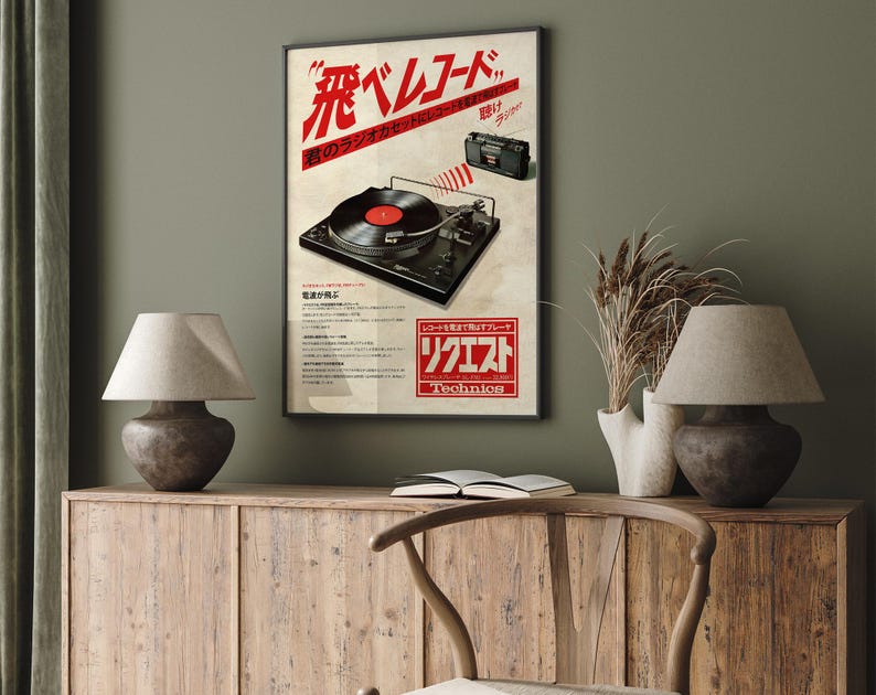 May include: A vintage poster advertising a Technics record player. The poster features a black and silver record player with a red record on the turntable. The poster is in Japanese and English and says "The sound of the music you love."