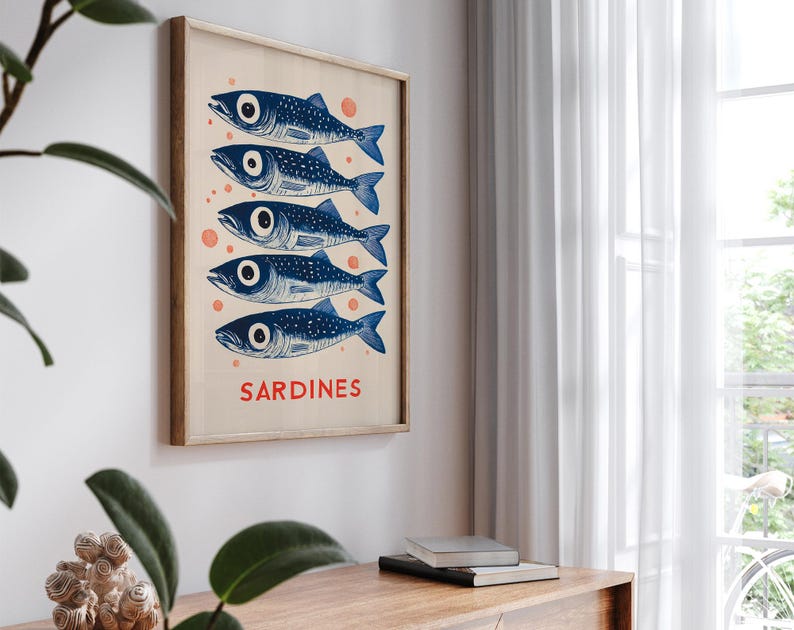 Może przedstawiać: Plakat w stylu vintage z niebiesko-białą ilustracją pięciu sardynek. Plakat ma jasną drewnianą ramę, a słowo "SARDYNKI" jest nadrukowane na dole na czerwono.
