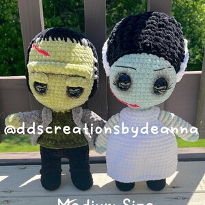 May include: Two crocheted dolls, one resembling Frankenstein's monster and the other the Bride of Frankenstein. The Frankenstein doll is green with black hair and a gray jacket. The Bride doll is light blue with black hair and a white dress. The text "Medium Size" is at the bottom.