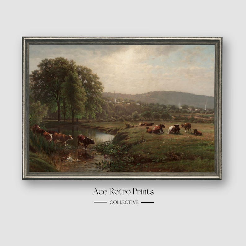 May include: A vintage painting depicting a pastoral scene with a stream running through a grassy field.  The painting features a group of brown and white cows grazing in the field.  The background shows a small village nestled in a valley.