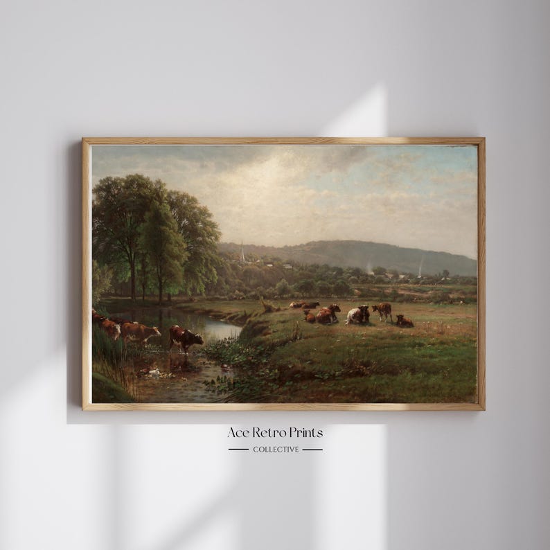 May include: A vintage painting depicting a pastoral scene with a stream running through a grassy field.  The painting features a group of cows grazing in the field, with a small village in the distance.  The sky is a soft blue with fluffy white clouds.