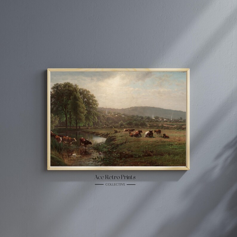 May include: A vintage painting depicting a pastoral scene with a stream running through a grassy field.  The painting features a group of cows grazing in the field, with a lush green forest in the background.  The sky is a light blue with fluffy white clouds.