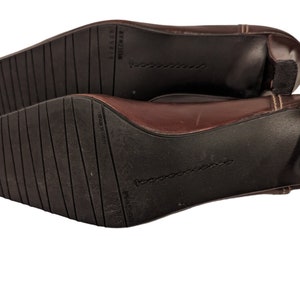 Pu&ograve; includere: Scarpe con tacco in pelle marrone con punta a punta e tacco piccolo. Le scarpe hanno una suola testurizzata e il nome del marchio "Nine West" &egrave; stampato sulla suola.