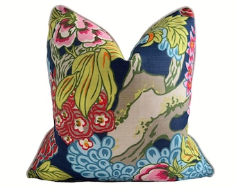 May include: A blue cushion with a floral pattern featuring pink, red, yellow, and green flowers. The cushion has white piping around the edges.