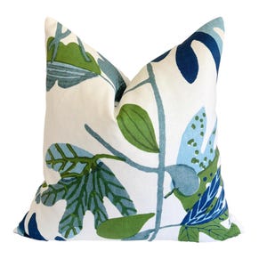 May include: A square cushion featuring a botanical design with green and blue leaves on a white background. This decorative pillow is suitable for home decor and measures approximately 40 cm x 40 cm.