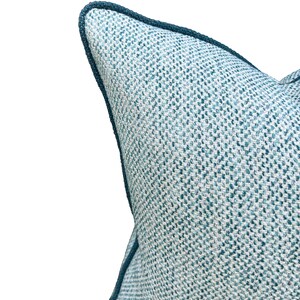May include: A blue and white patterned throw pillow with a dark blue trim. The pillow is made of a woven fabric and has a soft, comfortable feel.