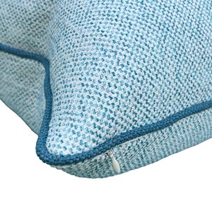 May include: A blue and white patterned throw pillow with a zipper closure.