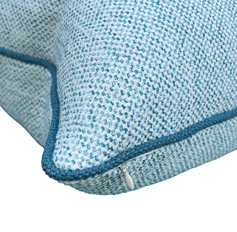 May include: A blue and white patterned throw pillow with a zipper closure.