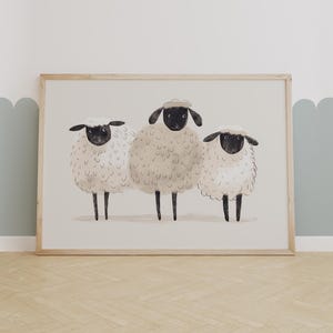 May include: A framed print depicting three white sheep with black faces. The sheep are standing in a row, looking forward. The background is a light beige colour.