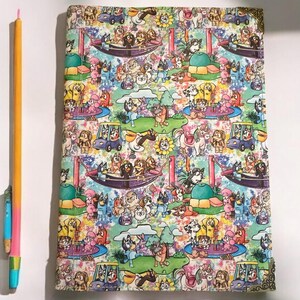 Può includere: Una copertina per quaderno colorata con un motivo ripetitivo di cani dei cartoni animati che giocano in un parco. I cani indossano vestiti di diversi colori e sono circondati da alberi, fiori e altri elementi del parco.