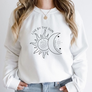 May include: White sweatshirt with a black sun and moon graphic and the text "Live by the sun, love by the moon".