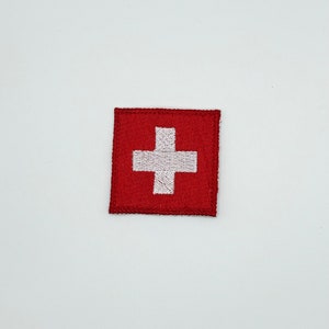 May include: A red embroidered patch with a white Swiss cross.