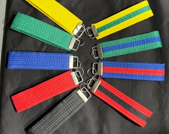 May include: Seven different colored martial arts belt keychains with silver key rings. The belts are black, red, blue, green, yellow, and two shades of green.