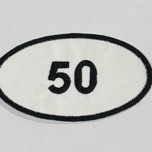 May include: White oval patch with black stitching and the number 50 embroidered in black.