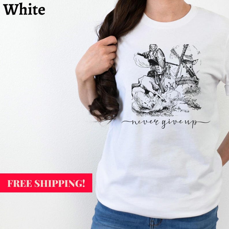 Woman standing against a wall wearing a white shirt with the words never give up in a simple cursive font of black. Above that is an illustration of Don Quixote fighting a windmill. Free shipping.