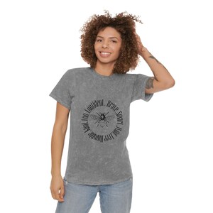 Peut inclure: Un t-shirt gris avec un motif d'abeille noir et le texte "Soyez confiant. Prenez du miel. Vous vous en sortez bien !" imprimé sur le devant.