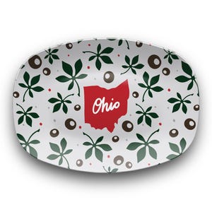 May include: Oval serving platter with a white background, featuring a pattern of green leaves, brown circles, and red dots. A red outline of Ohio with the word "Ohio" in white script is in the center.