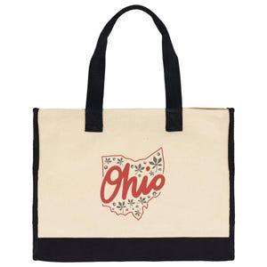 May include: Cream-colored tote bag with black handles and a black base. The bag features a red outline of the state of Ohio with the word "Ohio" in a cursive font. The Ohio outline is decorated with floral and leaf designs.