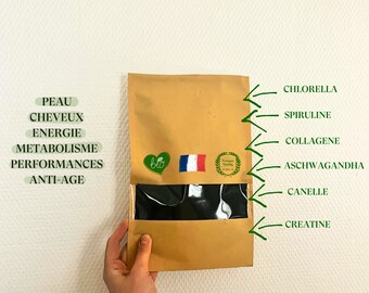 May include: A brown paper bag with a clear window, containing a dark substance. The bag has a French flag and a green bio logo. Text on the bag includes "Chlorella", "Spiruline", "Collagene", "Ashwagandha", "Canelle", and "Creatine".