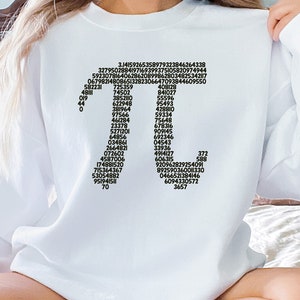 May include: White sweatshirt featuring a black graphic of the mathematical constant pi, displayed as a sequence of numbers arranged in the shape of the Greek letter pi.