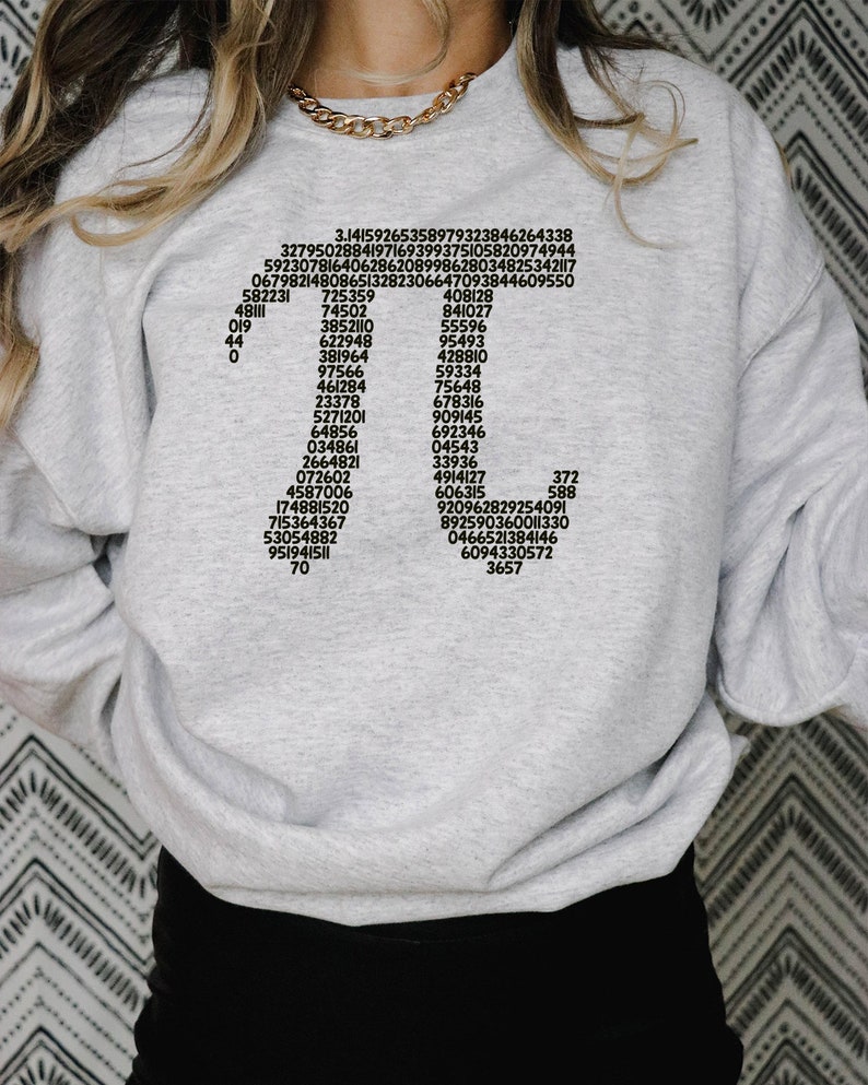 May include: A grey sweatshirt with black text printed on the front. The text includes a series of numbers, including 3.14159265358979323846264338, 3279502884197169399375105820974944, 592307816406286208998628034825342117, 067982148086513282306647093844609550, 408128, 841027, 55596, 95493, 428810, 59334, 75648, &pi;, 582231, 725359, 48111, 74502, 019, 3852110, 44, 622948, 0, 381964, 97566, 461284, 23378, 678316, 5271201, 909145, 64856, 034861, 692346, 04543, 2664821, 072602, 33936, 4914127, 4587006, 606315, 174881520, 715364367, 53054882, 951941511, 70, 372, 588, 920962829254091, 892590360011330, 0466521384146, 6094330572, 3657.