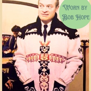 May include: A white knitted sweater with a black, red, and blue patterned design. The sweater features a totem pole design with a bird, a bear, and a human figure. The text "WORN BY BOB HOPE" is visible in the image.