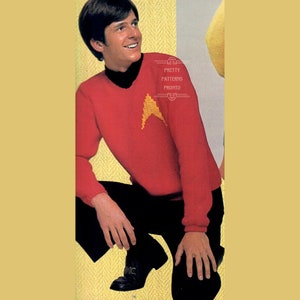 Op de afbeelding: Een rode gebreide trui met een geborduurd Starfleet-insigne in geel. De trui heeft een rolkraag en lange mouwen.