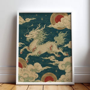 Könnte beinhalten: Ein gerahmter Kunstdruck, der einen mythischen weißen Drachen mit fließender Mähne und Schweif in einer dynamischen Sprungpose zeigt. Der Drache ist vor einem dunkel-türkisfarbenen Hintergrund mit stilisierten beigen Wolken, goldenen Sternen.