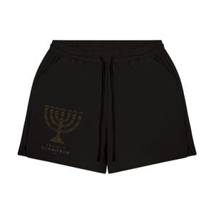 Könnte beinhalten: Schwarze Sportshorts mit elastischem Bund und schwarzen Kordelzügen. Auf dem linken Hosenbein befindet sich ein goldfarbener Aufdruck einer siebenarmigen Menora, ergänzt durch den Schriftzug "PROJECT GIBBORIM" in goldenen Buchstaben.